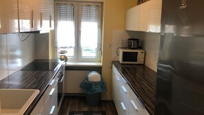 A compact kitchen with a stove, microwave, and refrigerator.