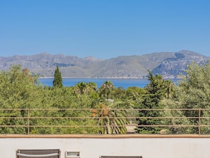 Un balcon avec vue sur un plan d’eau et des montagnes.