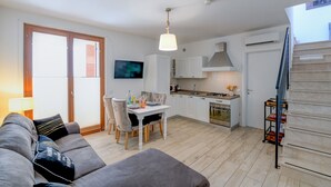 Un appartement moderne comprenant un salon, un coin repas, une cuisine et un escalier.