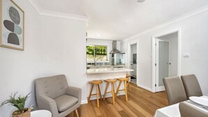 Ett modernt vardagsrum med en grå soffa, trästolar och ett matbord.