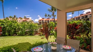 A table set outdoors with a view of a hotel complex and lush greenery.