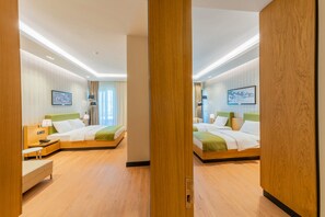 A modern hotel room with two beds, wooden flooring, and a large mirror. - Artes Hotel (Defne)