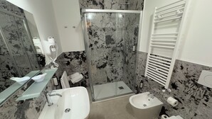 A modern bathroom with a glass-enclosed shower, a white sink, a bidet, and a toilet. - Residenza Briati (Venice)