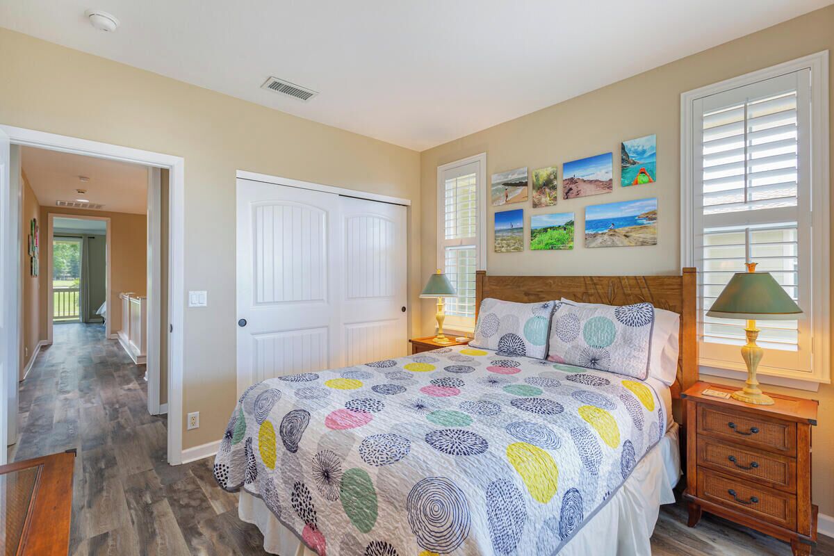 Un dormitorio con cama, mesita de noche, lámpara y puerta.