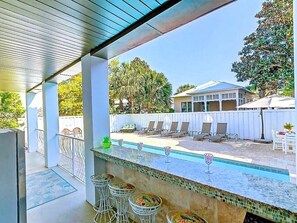 Un espace extérieur abrité comprenant une piscine, des chaises longues et une table à manger.
