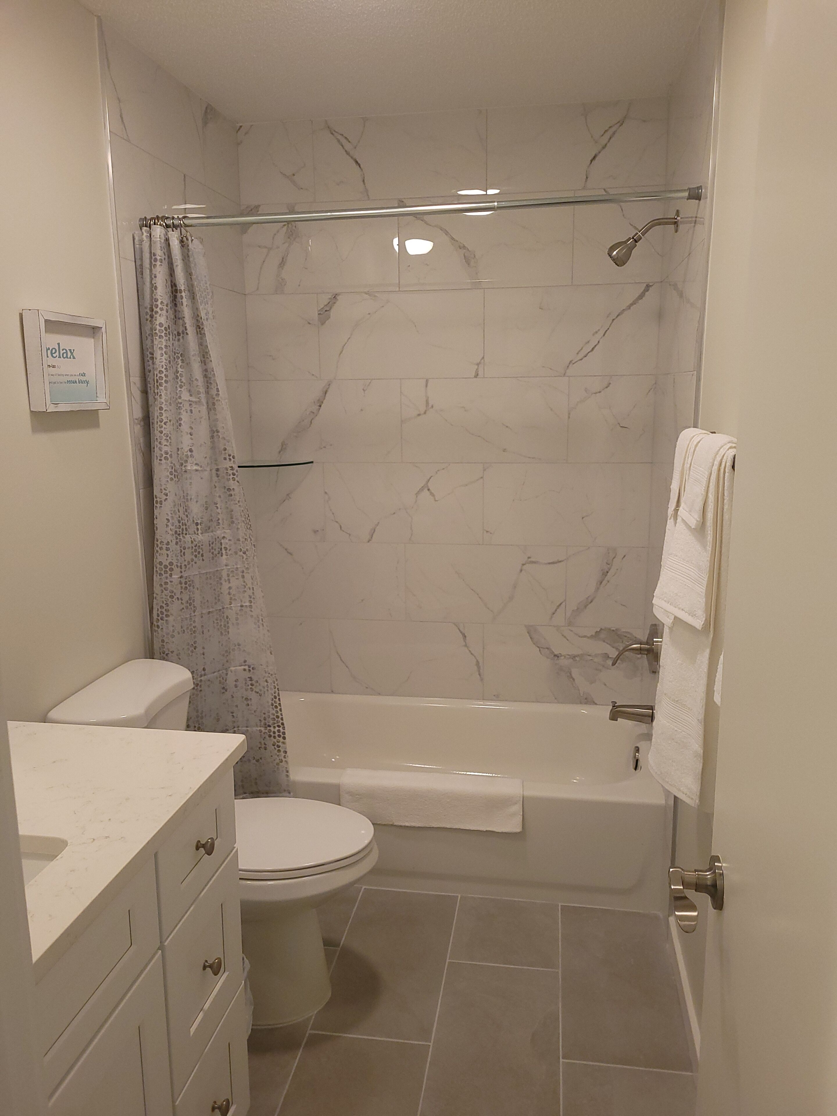 A bathroom with a toilet, bathtub, and shower.