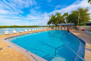 Relax by the pool surrounded by lush greenery and comfortable lounge chairs.