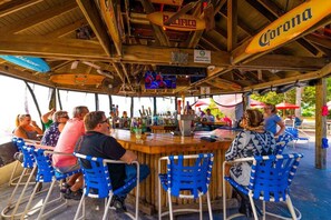 Relax with a drink at our outdoor bar, featuring a central counter and comfortable seating.