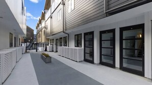 A narrow urban alley with modern buildings, large windows, and a central planter. - Central Queenstown Apt 15a - with Gym walk to town (Queenstown)