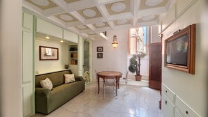 A hallway with a green sofa, a round table, and a chandelier. - Outdoor jacuzzi in old town w/ fantastic sea view (Castro)