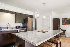 A modern kitchen with granite countertops, stainless steel appliances, and pendant lighting. - Koa Resort 1B: Garden View Condo w/ AC, Shared Hot Tub & Pool (Kihei)