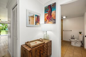 A clean, modern bathroom with a toilet, a small plant, and a towel. - Koa Resort 1B: Garden View Condo w/ AC, Shared Hot Tub & Pool (Kihei)