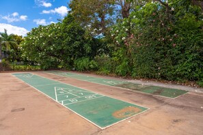 Una cancha de juego de bolos rodeada de abundante vegetación y árboles.