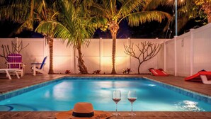 A swimming pool with two glasses of wine and a straw hat on the edge. - Pickleball, Game Room, Heated Pool, 4 Min to Beach (Bradenton)