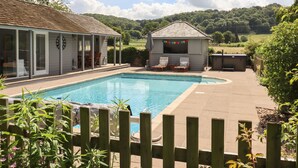 A pool area with a covered seating area and a hot tub. - The Coach House (Ross-on-Wye)