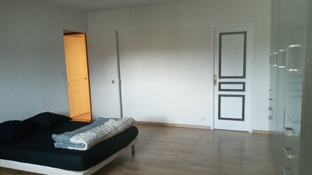 A bedroom with a bed, a door, and a wardrobe. - L'hote 640 (Tarnos)