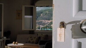 A room with a view of a mountainous landscape through a window.