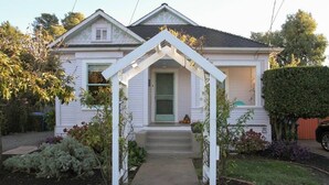 A house with a porch, a door, and a small garden.