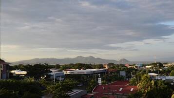 A cityscape with a gas station, buildings, and mountains in the background.