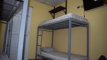 Habitación con literas y un televisor montado en la pared.