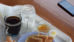 A tray with toast, orange juice, coffee, milk, and butter. - Orison Managua (Managua)
