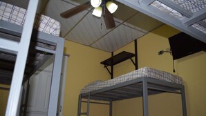 A dormitory room with bunk beds, a ceiling fan, and a window with a curtain. - Orison Managua (Managua)