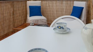 A room with a table and chairs, large windows, and a view of greenery outside. - Independent Apartment in the heart of Milan (Milano)