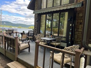 Una terraza con mobiliario exterior y vista a un lago.