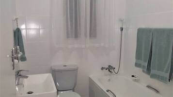 Un baño con inodoro, lavabo y bañera.