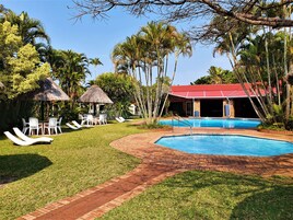 Una piscina al aire libre, sillones reclinables de piscina