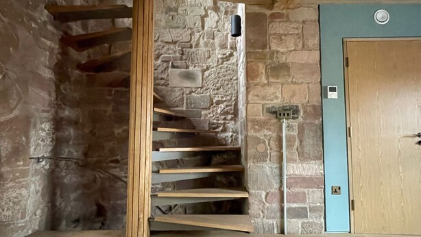 A stone staircase with wooden steps leading to a landing. - Coventry Historic Houses (Coventry)