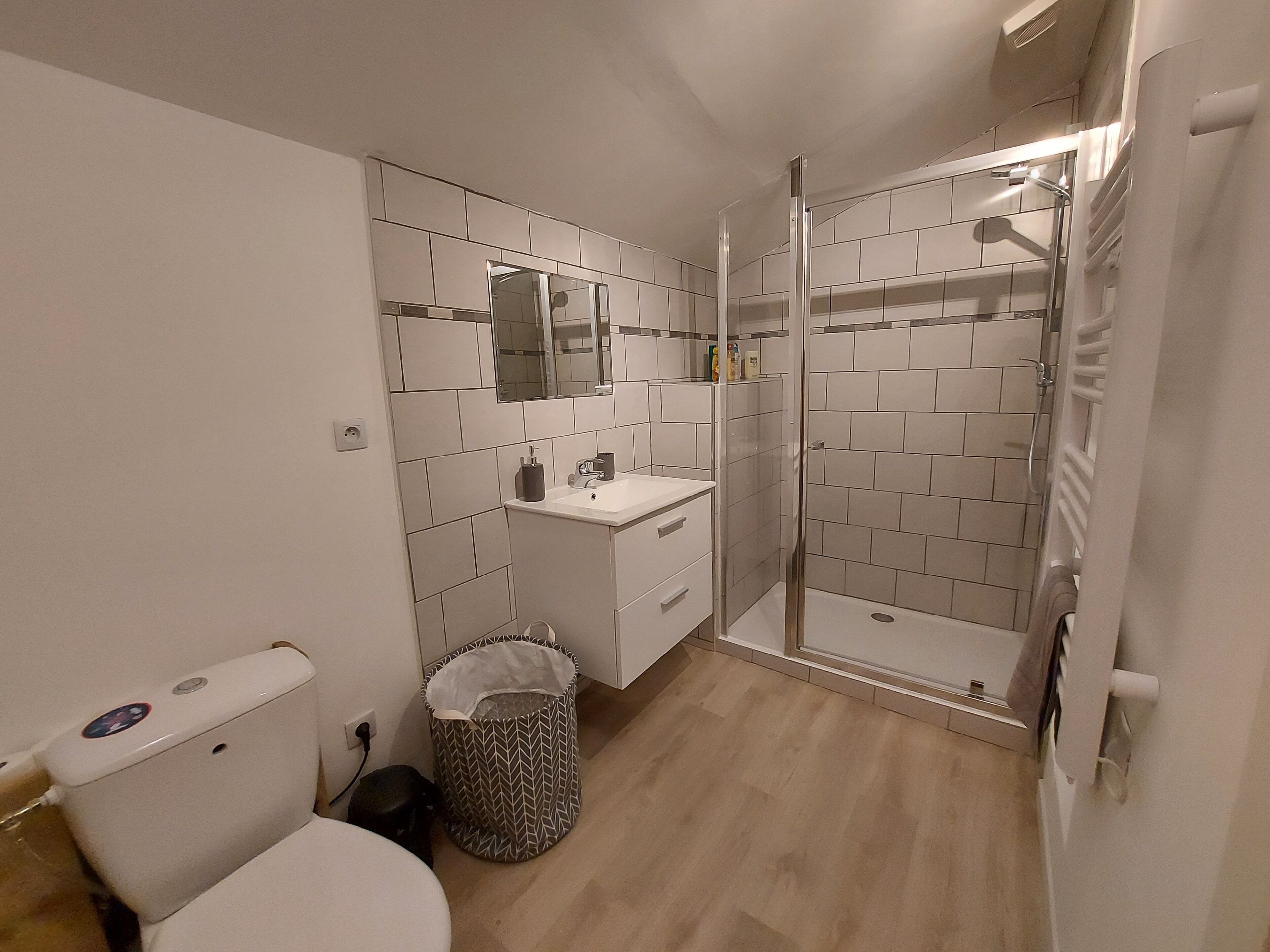 Une salle de bain avec des toilettes, un lavabo et une douche.