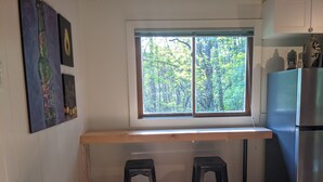A kitchen with a built-in window, two stools, and a stainless steel refrigerator. - Country road take me home! (Boone)