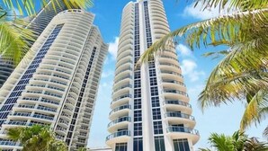 Two tall, cylindrical high-rise buildings with balconies, surrounded by palm trees. - Oceanview Apt at Marenas Resort, Sunny Isles Beach with Direct Beach Access!  (Sunny Isles Beach)