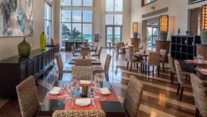 A spacious dining area with high ceilings and large windows, featuring modern furniture and a view of the outdoors. - Oceanview Apt at Marenas Resort, Sunny Isles Beach with Direct Beach Access!  (Sunny Isles Beach)