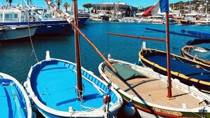Uma marina com vários barcos atracados, uma bandeira e um edifício ao fundo.