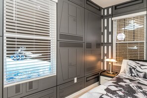 A bedroom with a large wardrobe, a bedside table with a lamp, and a window with blinds. - Harry Themed-room, Spacious and Luxurious Villa #6st560 (Davenport)