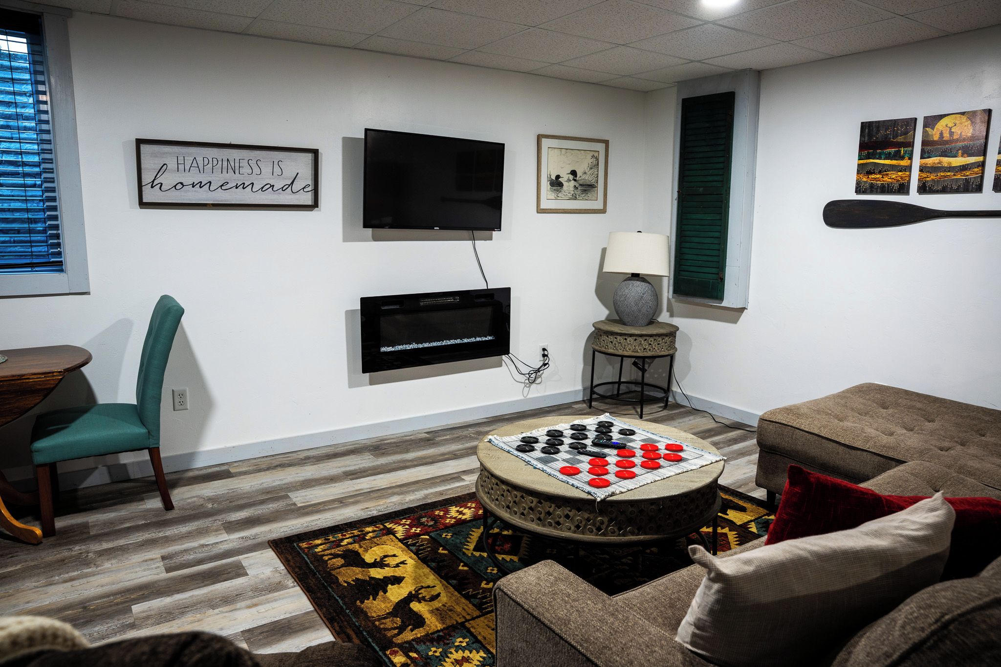 Un salon avec une télévision, un jeu d’échecs, une lampe et un canapé.
