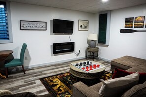 A living room with a television, a chessboard, a lamp, and a couch. -  Lake Metonga Cabin (Crandon)