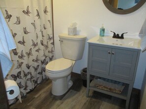 Tina con regadera, toallas, jabón, shampoo