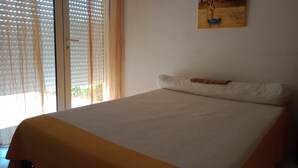 Una camera da letto con un letto, una finestra con persiane e un quadro appeso al muro.
