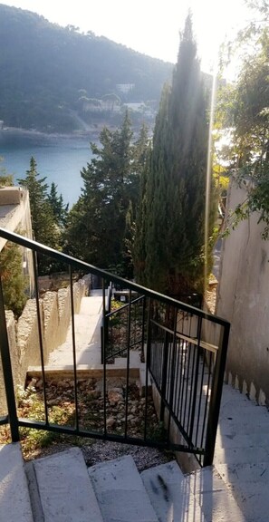 A staircase leading to a terrace with a view of a lake and trees. - 2 Bedroom Apartment conveniently situated a few steps from the sea in Lapad Bay (Dubrovnik)