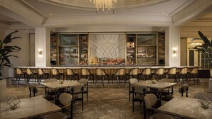 A bar area with multiple seating arrangements and a large, well-lit bar counter.