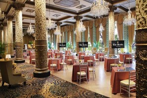 A banquet hall with round tables, red tablecloths, and ornate columns. - 2 Connecting Suites at a 4⭐️ Hotel (Chicago)