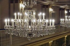A grand chandelier with multiple candles, ornate metalwork, and crystal decorations. - 2 Connecting Suites at a 4⭐️ Hotel (Chicago)