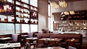 Un ristorante con tavoli e panche in legno, un'area cucina e un'ampia finestra con vista.