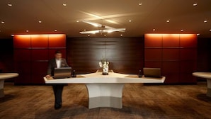Una reception con due computer portatili, un vaso di fiori e un moderno design del soffitto.