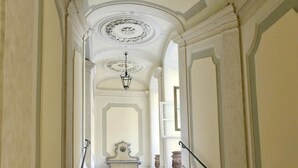 Una imponente escalera con molduras ornamentales y un techo decorativo.