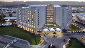 A large, modern hotel with a prominent glass facade and multiple levels.
