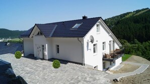 A modern two-story house with a sloped roof, satellite dish, and a balcony. - Vacation apartment Ritzhagen in Willingen (Willingen)